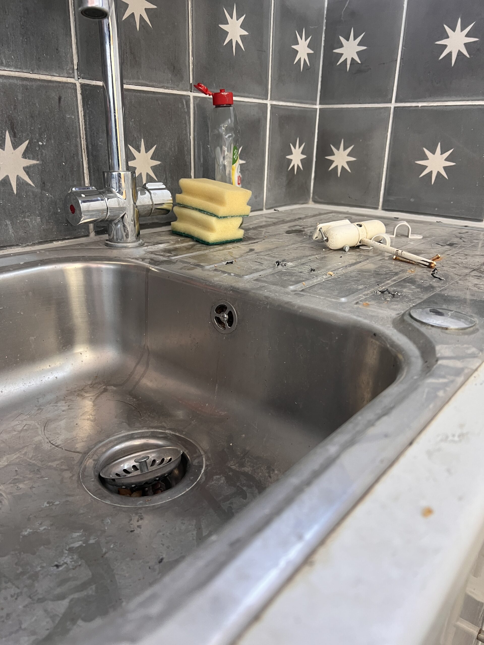Stainless steel kitchen sink and drainer before cleaning